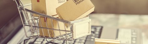 photo of a toy shopping cart with little shipping boxes on top of a laptop keyboard