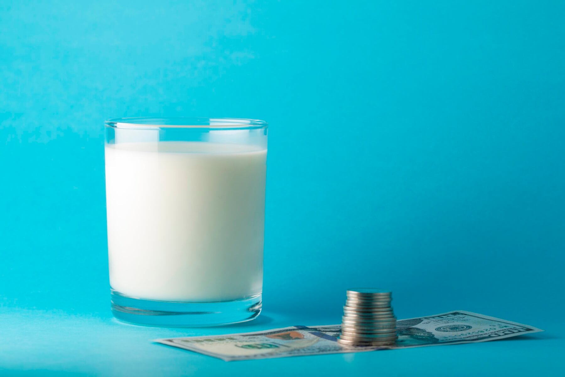 photo of a glass of milk and money next to it